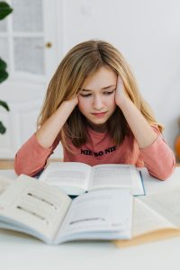 Photo of anxious Caucasian girl homeschooling during Covid-19 before starting online anxiety treatment in Illinois. 