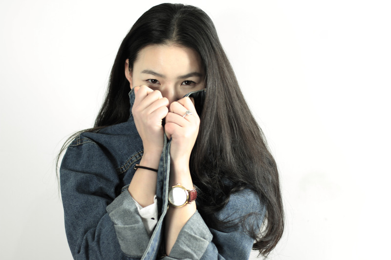 Photo of Asian female teen with her denim shirt pulled up over half her face to her eyes. Photo could represent the social anxiety she feels and the need for online Christian counseling for kids and teens in Illinois and Florida.